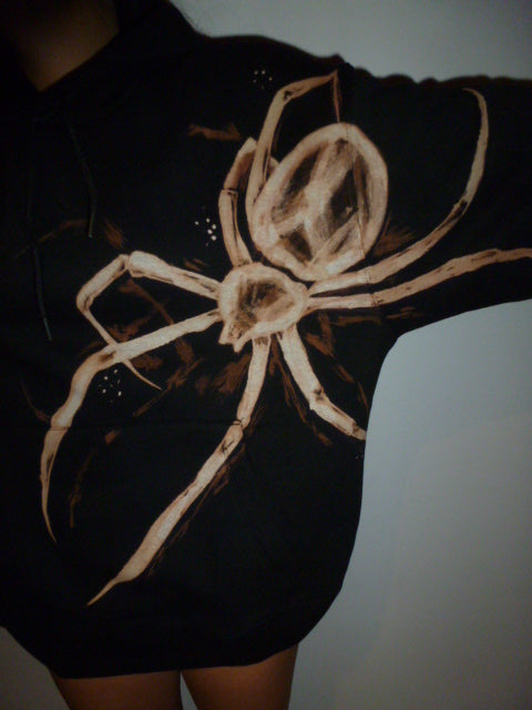 Black shirt with a spider design done with bleach.