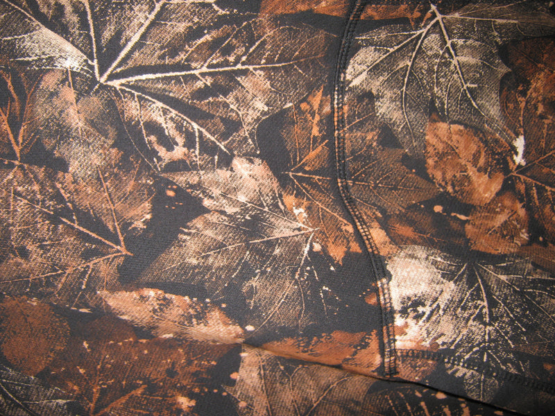 Close-up of a camouflage pattern with brown, black, and beige leaves.