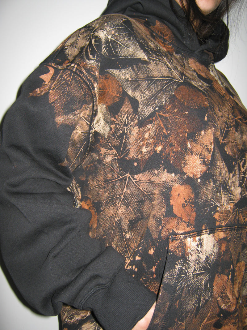Camouflage-patterned jacket with leaf design on a plain background