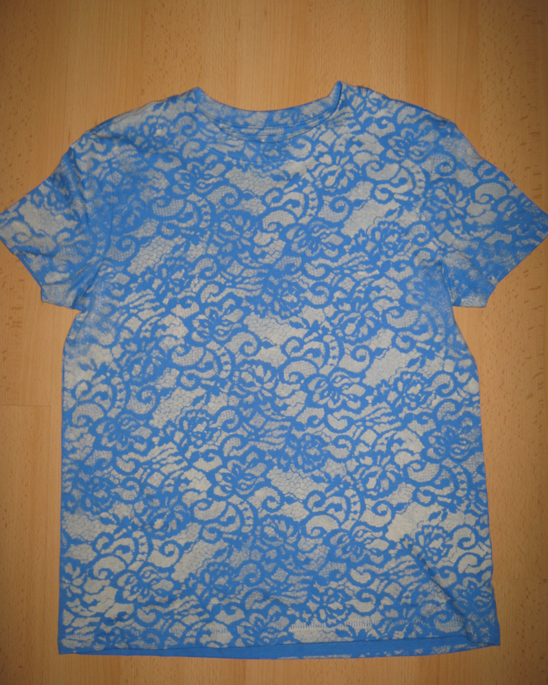 Blue lace-patterned shirt on a wooden surface
